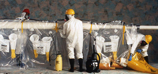 3 workers covering pipe with asbestos glove bag